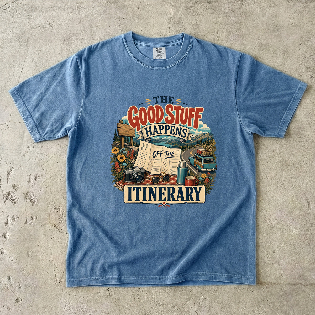 The Good Stuff Happens Off the Itinerary Travel Mom Shirt in Blue Jean – flat lay