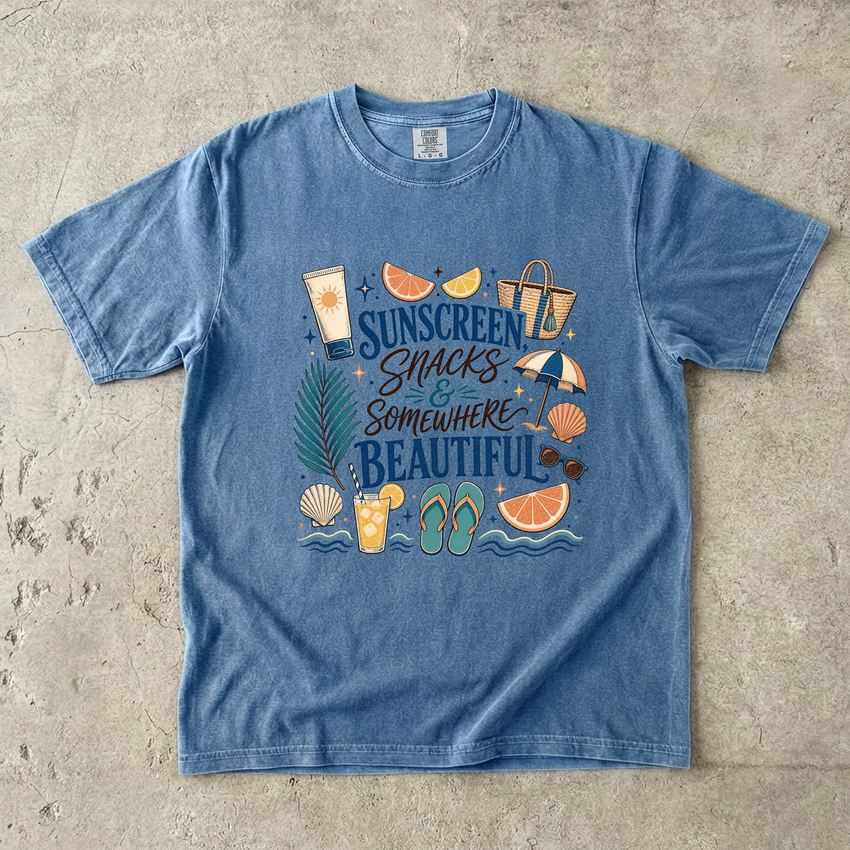 Sunscreen Snacks and Somewhere Beautiful Beach Vacation Shirt in Blue Jean – flat lay