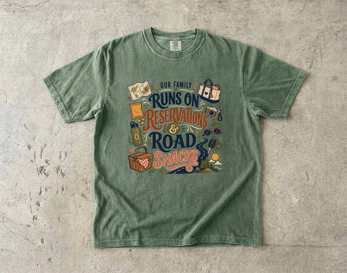 Our Family Runs on Reservations and Road Snacks Road Trip Shirt in Moss – flat lay